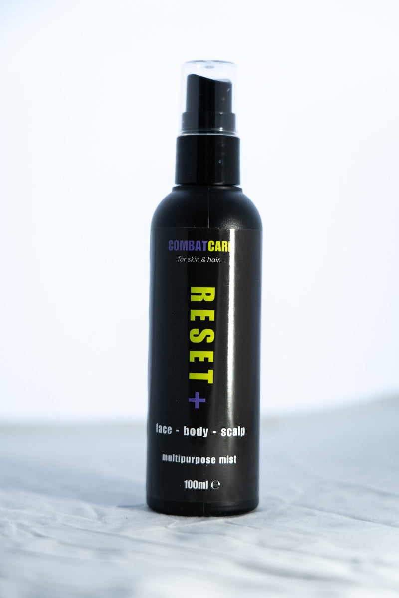 Black spray bottle labeled 'Combat Care Reset' on a white background