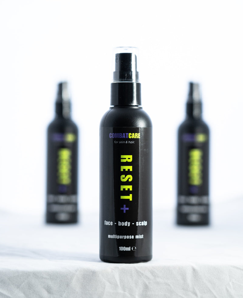 Black spray bottles labeled 'Combat Care' on a white background